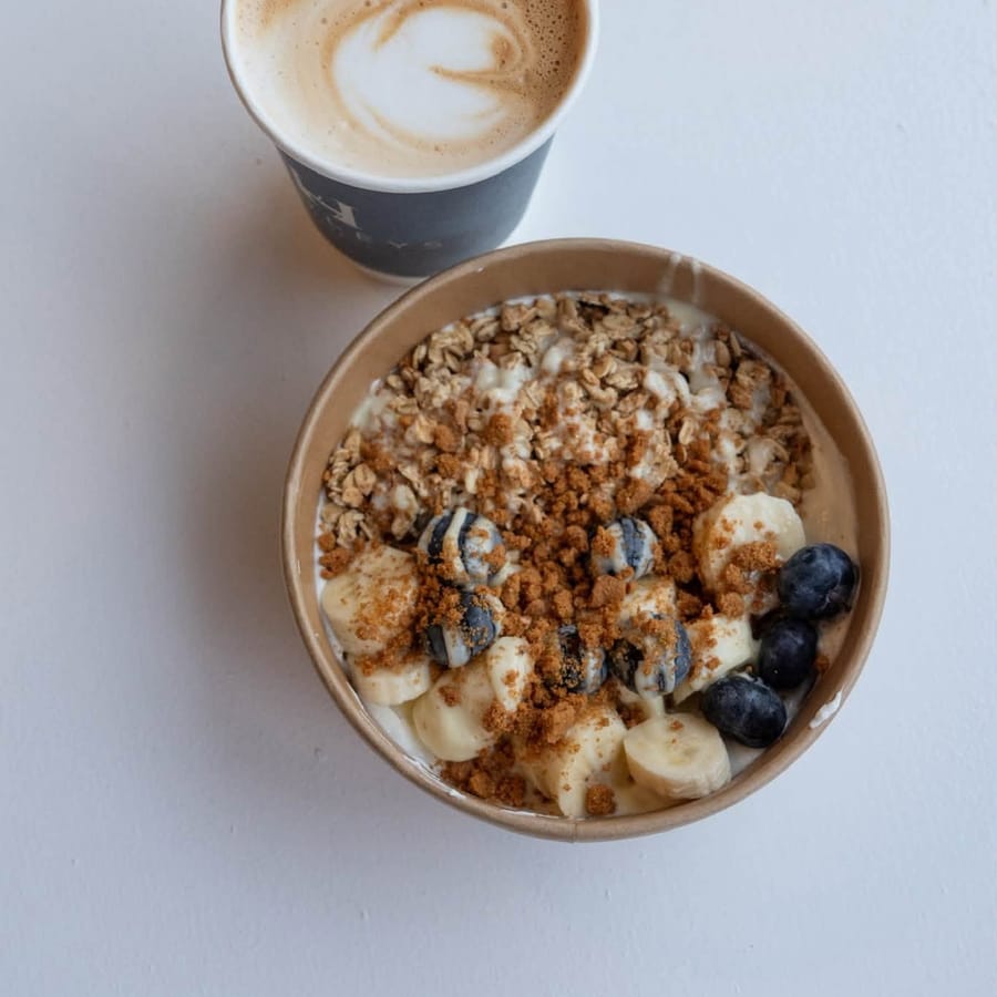 A latte and a yoghurt bowl from above